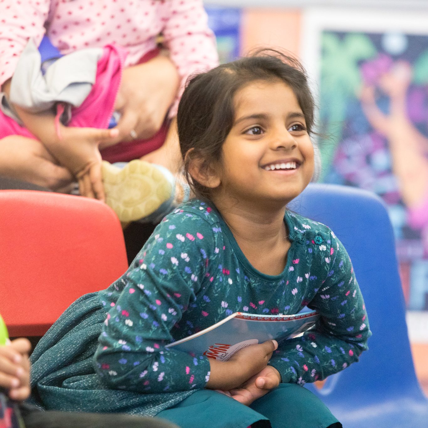 Smiling child is holding a book and smiling