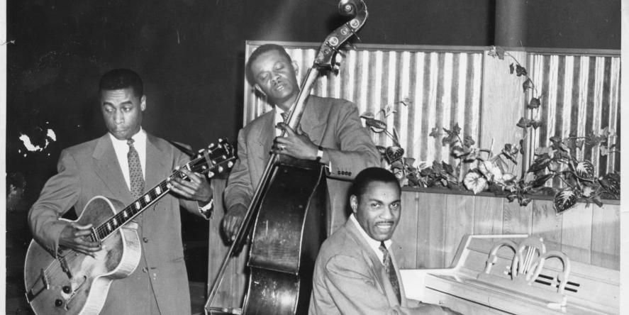 Musicians Bob Lewis (bass), Norvell Randell (piano), Eric Miller (guitar)on stage at Slim Jenkins Bar and Restaurant Oakland, California